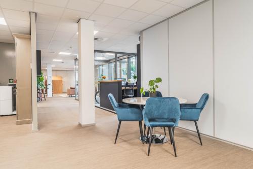Kantoorruimte huren in Utrecht Papendorp met een open vloerplan. Het kantoorpand heeft een moderne inrichting met comfortabele blauwe stoelen rondom een tafel.