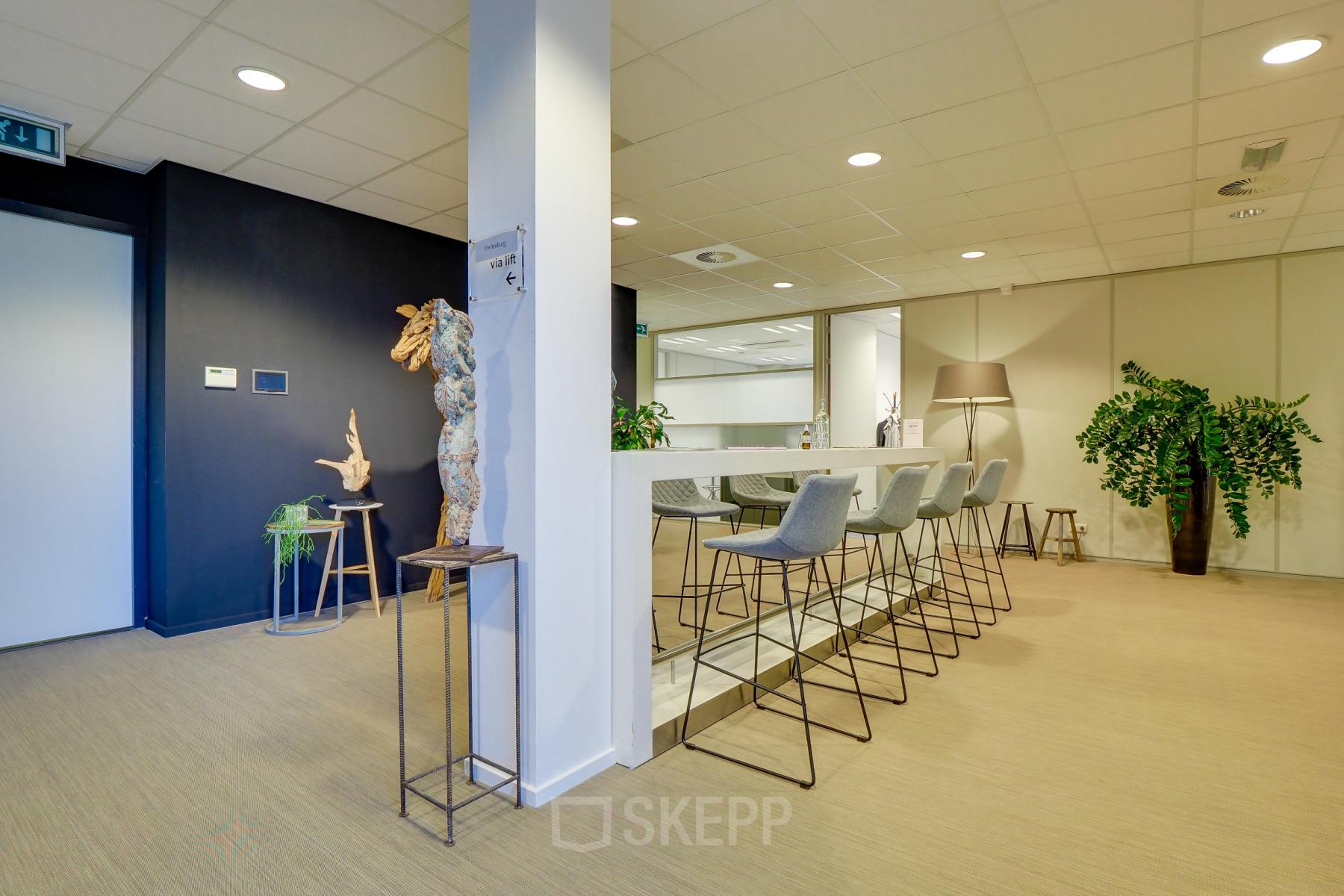 Moderne en lichte kantoorruimte in Utrecht Papendorp aan de Orteliuslaan 850, met hoge stoelen en een bar voor informele meetings.