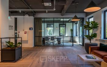 Moderne vergaderruimte in een kantoorpand op Euclideslaan 265, Utrecht Rijnsweerd. Glaswanden en planten creëren een open werkplek met een lichte uitstraling, ideaal voor wie kantoorruimte wil huren.