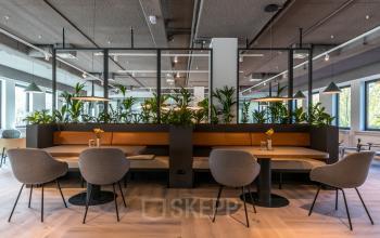 Moderne kantoorruimte huren met comfortabele zitjes, glazen wanden en veel groen, gelegen aan de Euclideslaan 265 in Utrecht Rijnsweerd. Warm verlichte ruimte ideaal voor informele vergaderingen.