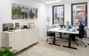 Moderne werkplek in een kantoor aan de Euclideslaan 265 in Utrecht met een persoon aan het werk achter een bureau.