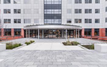 Vooraanzicht van het moderne kantoorpand op Varrolaan 100-126 in Utrecht Rijnsweerd met ruime entree en glazen deuren.
