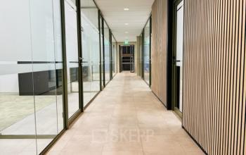 Kantoorruimte met glazen wanden en houten panelen op Varrolaan 100-126, Utrecht Rijnsweerd. Deze moderne ruimte biedt flexibiliteit voor diverse werkopstellingen. Ideaal voor kantoorruimte huren.