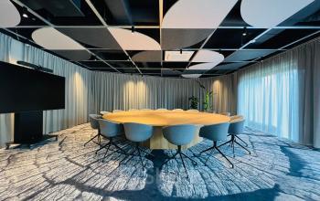 Stijlvolle vergaderruimte met een grote, ronde tafel en comfortabele stoelen in kantoorpand Varrolaan 100-126 in Utrecht Rijnsweerd, ideaal voor kantoorruimte huren.