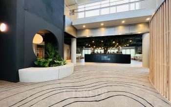 Ruime entree van een kantoorpand op Varrolaan 100-126 in Utrecht Rijnsweerd, met een moderne inrichting en veel natuurlijke elementen. Deze locatie biedt volop mogelijkheden voor kantoorruimte huren.