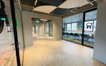 Moderne kantoorruimte op Varrolaan 100-126 in Utrecht Rijnsweerd met glazen wanden en neutrale vloeren, geschikt voor vergaderingen. Ideale plek voor kantoorruimte huren.