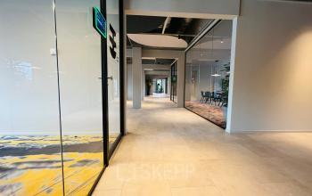 Ruime en moderne kantoorruimte aan de Varrolaan 100-126 in Utrecht Rijnsweerd met glazen wanden en zicht op vergaderruimte. Ideaal om kantoor te huren voor groeiende bedrijven.