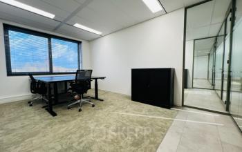 Kantoorruimte huren in een modern en licht kantoorpand op Varrolaan 100-126, Utrecht Rijnsweerd. Twee bureaus met stoelen en een kast aanwezig. Grote ramen voor natuurlijke lichtinval.