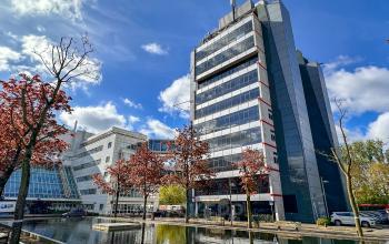Modern kantoorpand aan Daltonlaan 200, Utrecht Rijnsweerd, omgeven door bomen en een reflecterend wateroppervlak.