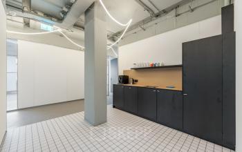 Kantoorruimte op Daltonlaan 200 in Utrecht Rijnsweerd met een strakke pantry met zwarte kasten, witte tegels en lichte muren, ideaal voor kantoorruimte huren.