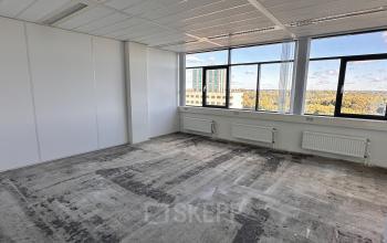 Lege kantoorruimte op Daltonlaan 200 in Utrecht Rijnsweerd met grote ramen, geschikt voor verhuur. Panorama-uitzicht op de stad en omliggende gebouwen.