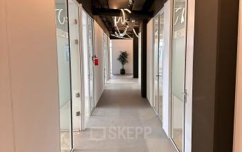 Gedeelde gang in een kantoorpand op Daltonlaan 200, Utrecht Rijnsweerd met glazen deuren naar kantoren en moderne verlichting.