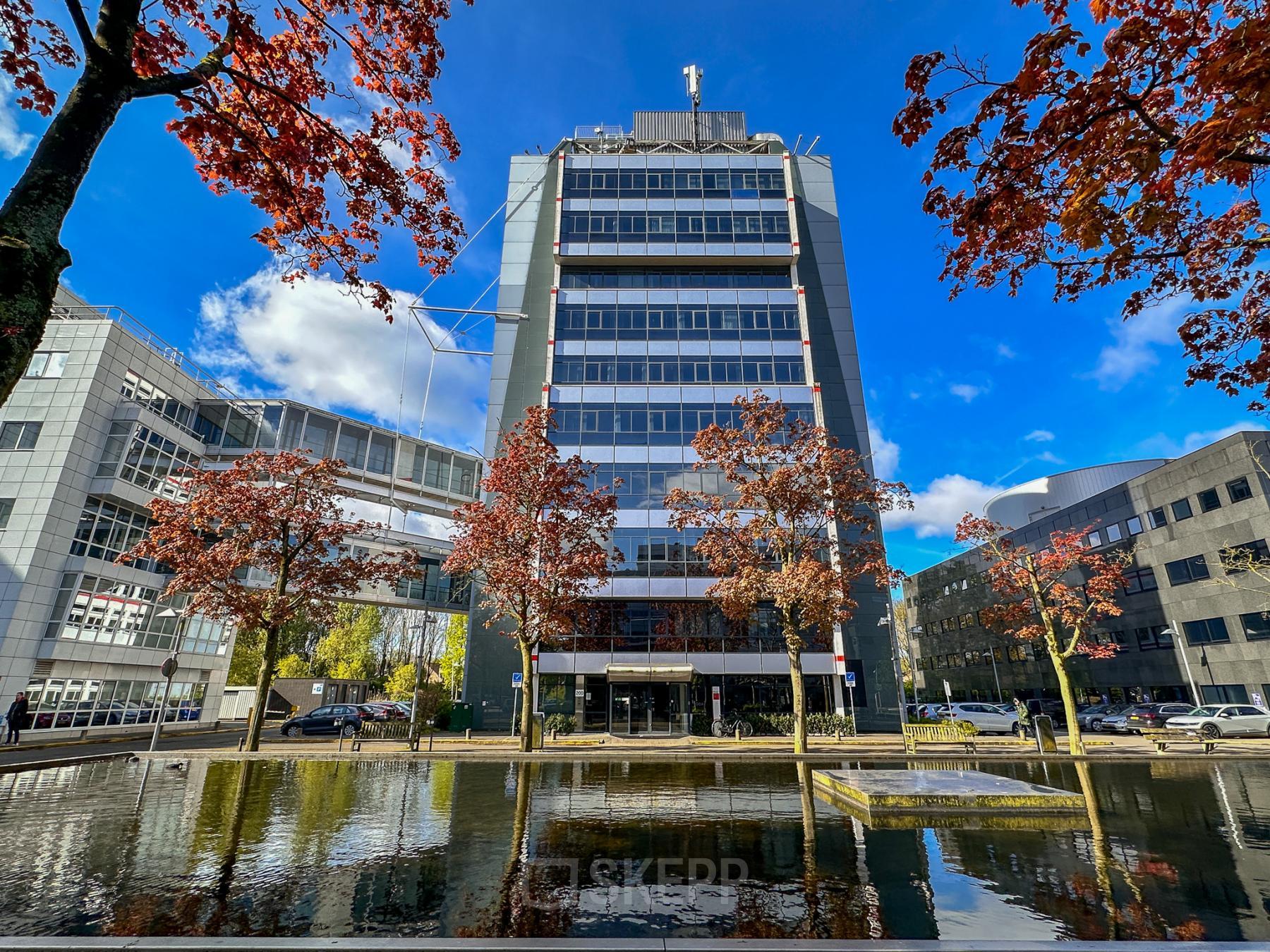 Modern kantoorpand gelegen aan de Daltonlaan 200 in Utrecht Rijnsweerd, omgeven door bomen en een waterpartij. Ideale locatie voor kantoorruimte huren met goede bereikbaarheid.