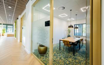 Modern kantoorpand aan de Euclideslaan 51 in Utrecht Rijnsweerd, met een stijlvolle vergaderruimte voorzien van houten tafel en comfortabele stoelen. Ideaal voor bedrijven die kantoorruimte willen huren.