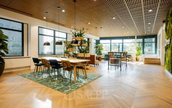 Ruim, licht kantoor aan Euclideslaan 51, Utrecht Rijnsweerd met moderne meubels, grote ramen, houten vloer en groene wanden. Perfecte plek om kantoorruimte te huren met stijl en comfort.