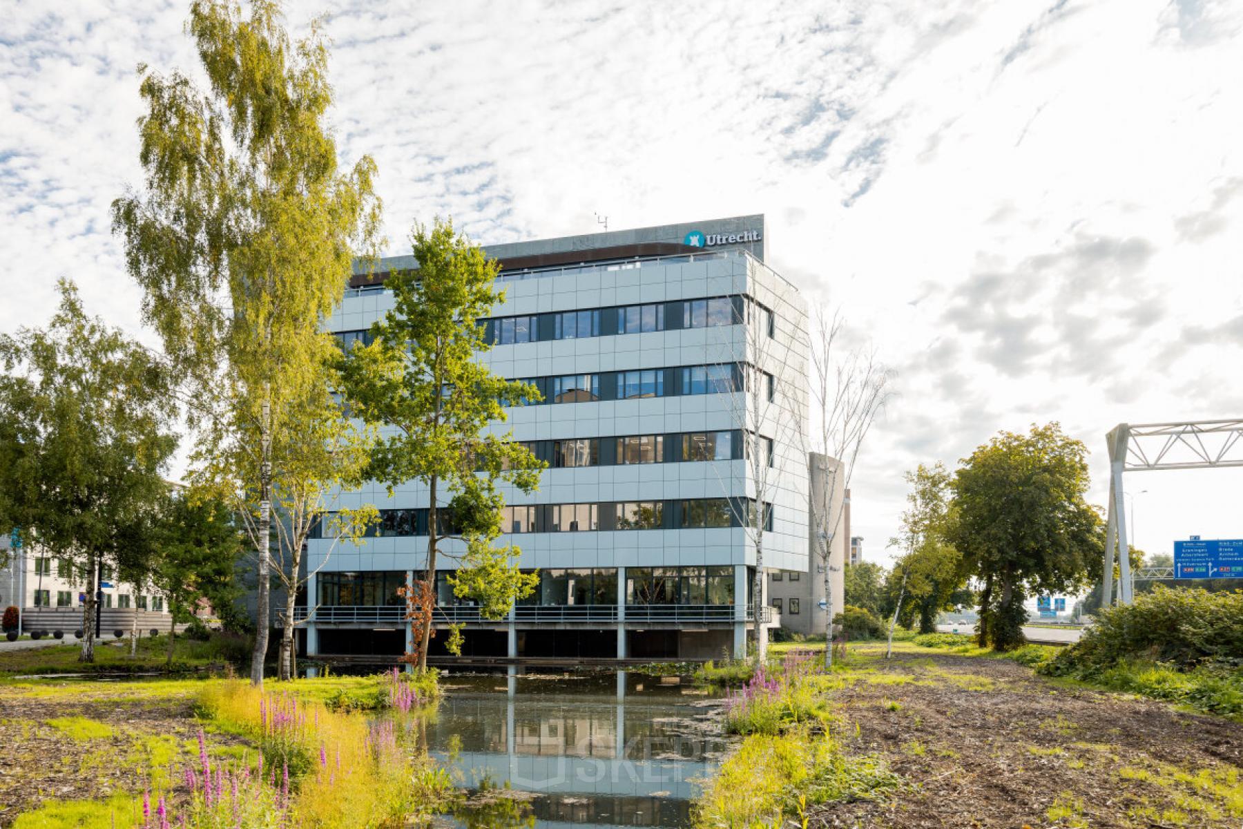 Modern kantoorpand aan de Euclideslaan 51 in Utrecht Rijnsweerd, omringd door bomen, met veel glas voor natuurlijk licht. Ideale locatie om kantoorruimte te huren in een professionele omgeving.