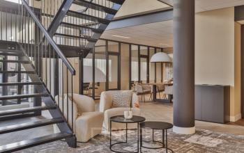 Moderne kantoorruimte op Niasstraat 1 1, Utrecht West met open trap en stijlvolle inrichting. Gezellige zithoek en tafels in een lichte, ruime omgeving. Ideaal voor bedrijven die kantoren willen huren.
