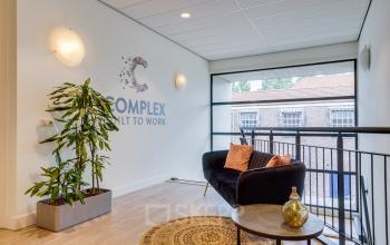 Ontvangstruimte van een kantoorpand aan de Kanaalweg 22 in Utrecht Zuid, met moderne inrichting en grote ramen die uitzicht geven op de omgeving. Ideaal voor bedrijven die kantoorruimte willen huren.