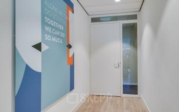 Binnenkant van het kantoorpand op Kanaalweg 22, Utrecht Zuid, met een fris ingerichte gang en inspirerend kunstwerk aan de muur.