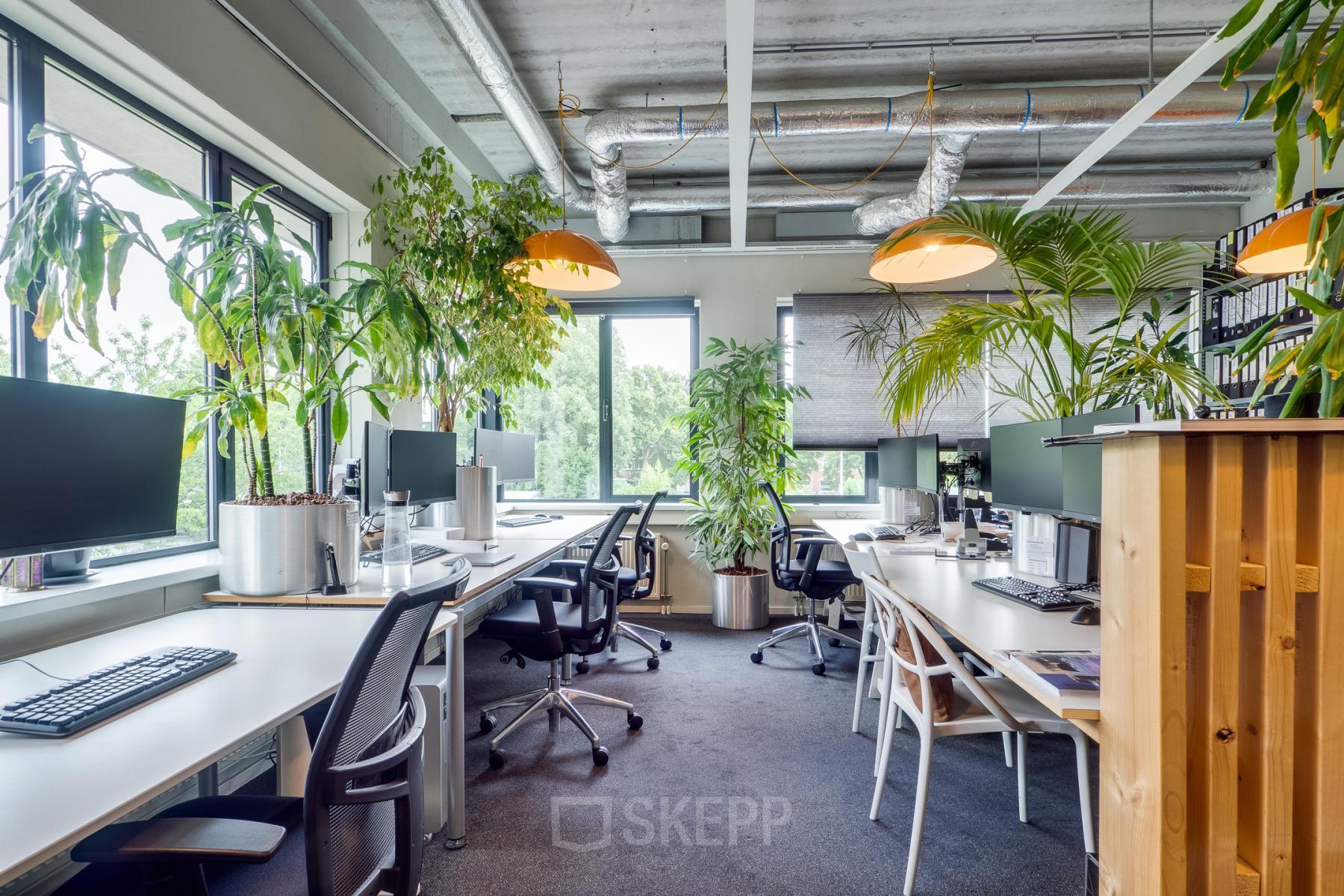 Kantoorruimte huren op Kanaalweg 22 in Utrecht Zuid met moderne werkplekken, groene planten, ergonomische stoelen en veel natuurlijk licht.