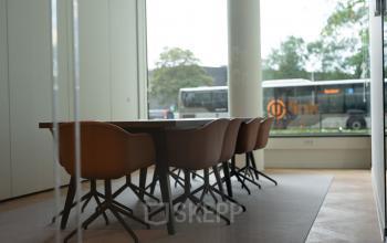 Vergaderruimte met lange tafel en moderne stoelen in een kantoorpand aan de Europalaan 40, Utrecht Zuid, ideaal voor kantoorruimte huren.