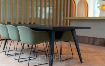 Kantoorruimte huren aan Europalaan 40 in Utrecht Zuid met stijlvol interieur. Zes groene stoelen geplaatst rondom een eigentijdse zwarte tafel, geschikt voor vergaderingen of teamoverleg in een modern kantoorpand.