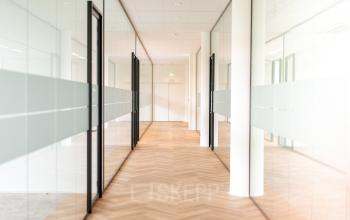 Ruime, heldere gang in kantoorpand op Europalaan 40, Utrecht Zuid, met glazen wanden en houten vloer, ideaal voor professioneel gebruik. Ontdek de mogelijkheden om kantoorruimte te huren in deze moderne omgeving.