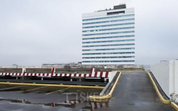 Exterieur van het kantoorpand op Churchilllaan 11, Utrecht Zuid, een modern wit gebouw met parkeerplaats op de voorgrond, kantoorruimte huren mogelijk.