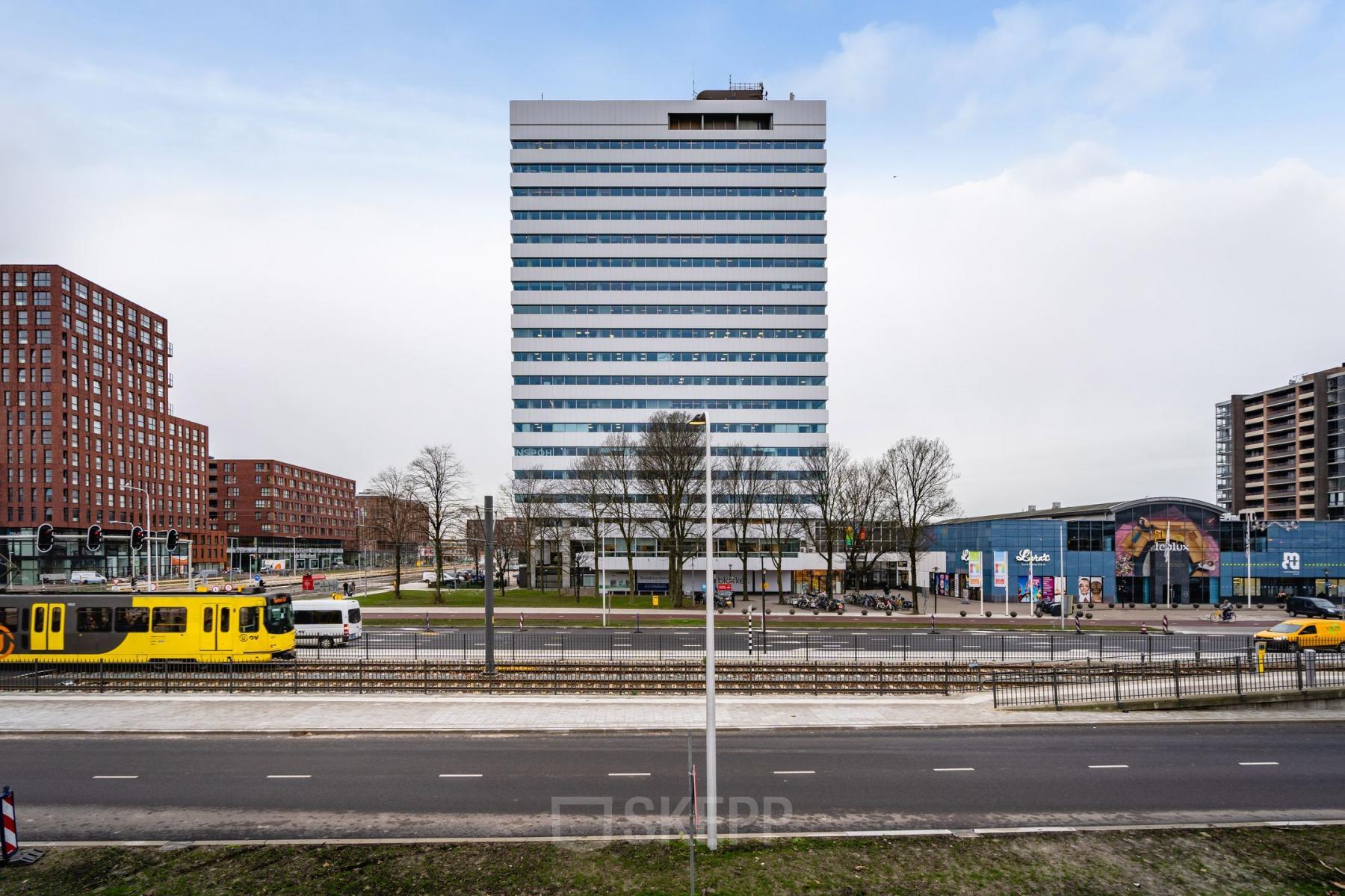 Kantoorpand aan Churchilllaan 11 in Utrecht Zuid, met opvallende toren in een levendige stadsomgeving, ideaal voor kantoorruimte huren.