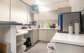 Kantoorruimte in Veenendaal op Vendelier 61, met een kleine keuken voorzien van een koffiezetapparaat en opbergkasten, ideaal voor een korte pauze tijdens het werk.