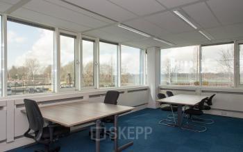 Kantoorruimte te huur op Vendelier 61 in Veenendaal, met ramen rondom voor veel natuurlijk licht, voorzien van bureaus voor productieve werkmomenten.