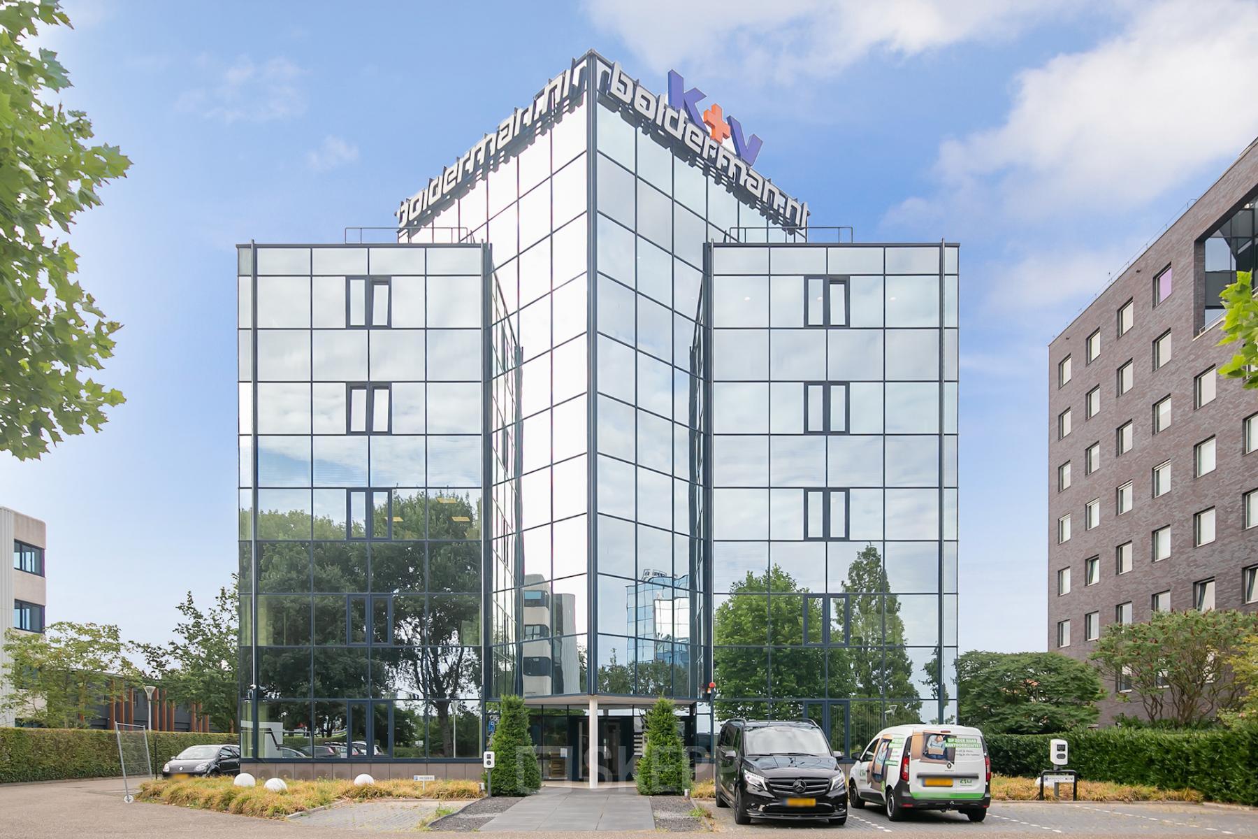 Modern kantoorpand Vendelier 61 in Veenendaal met spiegelende glasfaçade en ingangsgebied.