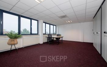 Lichte kantoorruimte op de Vendelier 59 in Veenendaal met grote ramen en moderne bureaus, ideaal voor het huren van een werkplek. Er staan geen mensen in de ruimte.