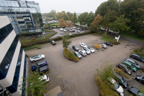 Exterieur van kantoorpand Vendelier 59 in Veenendaal met ruime parkeerplaats en groene omgeving, ideaal voor kantoorruimte huren.