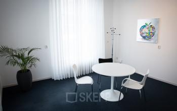 small office room with four chairs and a nice painting