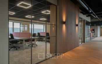 Moderne kantoorruimte met glazen wanden en stijlvolle houten afwerking bij Doornhoek 3745, Veghel. Ideaal voor open werkplekken en kantoorruimte huren.