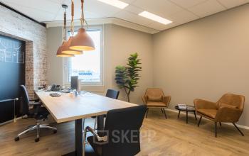 Modern ingerichte kantoorruimte huren op Costerweg 5, Veghel, met houten vloer, ruime bureaus en comfortabele stoelen, geschikt voor creatieve werksessies.