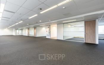 Ruime, lichte kantoorruimte te huur in Veldhoven, De Run 1141-1157, met moderne plafondpanelen en grijze vloerbedekking. Geschikt voor open werkplekken of andere kantoorinrichting.