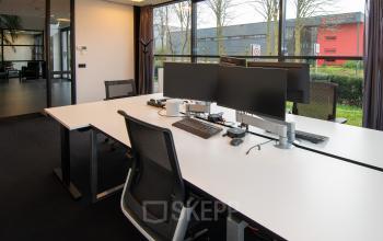 Moderne kantoorruimte met grote ramen en uitgeruste werkplekken op Gildestraat 13 in Velp, ideaal voor kantoorruimte huren. Inclusief strakke bureaus en comfortabele stoelen, dit kantoorpand biedt een professionele, lichte werkomgeving.