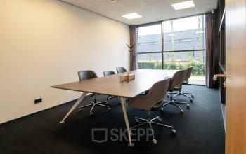 Zakelijke vergaderruimte in het kantoorpand op Gildestraat 13, Velp. Lichtinterieur met grote tafel en moderne stoelen. Ideaal voor kantoorruimte huren.