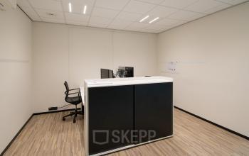 Kantoorruimte huren op Gildestraat 13 in Velp, met een strak interieur en een bureau met stoelen. Ideaal kantoorpand voor zakelijk gebruik.
