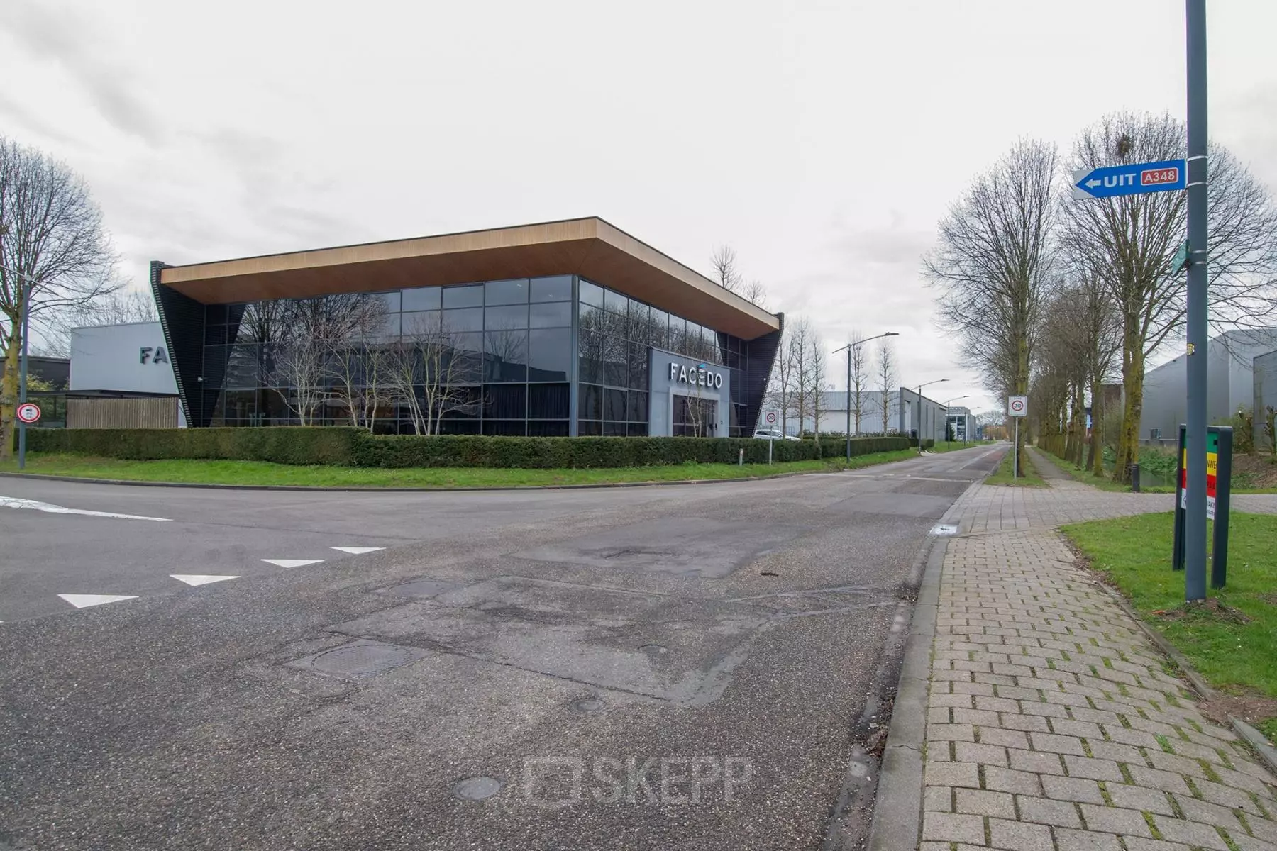 Modern kantoorpand op Gildestraat 13 in Velp, te huur, gekenmerkt door een strakke, glazen gevel en een rustige omgeving. Ideaal voor wie kantoorruimte zoekt.