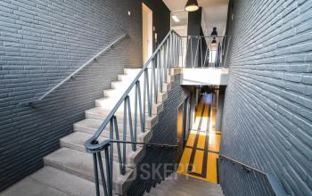 Trap in kantoorpand op Kaldenkerkerweg 28, Venlo, met zwarte muren en een glazen deur bovenaan. Ideale locatie om kantoorruimte te huren.