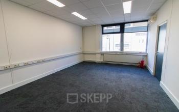 Ongemeubileerde kantoorruimte te huur op Kaldenkerkerweg 28 in Venlo, met vloerbedekking en grote ramen die voor veel natuurlijk licht zorgen.