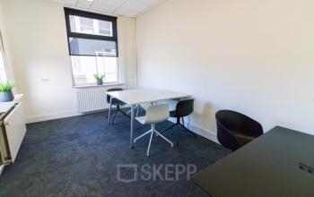 Kantoorruimte huren op Kaldenkerkerweg 28 in Venlo, met een netjes ingericht interieur inclusief drie stoelen en twee tafels. Grote ramen bieden natuurlijk licht in deze aangename kantooromgeving.