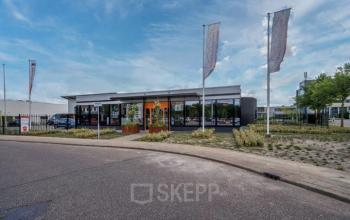 Exterieur van kantoorpand Noorderpoort 43 in Venlo met moderne gevel en vlaggen. Geschikt voor huur als kantoorruimte.