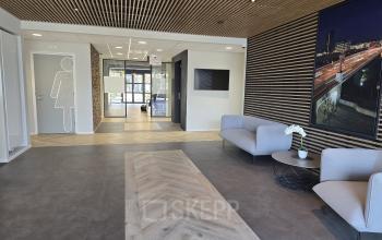 Moderne kantoorruimte op Noorderpoort 33 33 in Venlo met strakke houten details, comfortabele zitplaatsen en neutrale tinten, ideaal voor werk of ontvangsten.