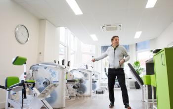 fitnessruimte zaal groene apparaten personal trainer 