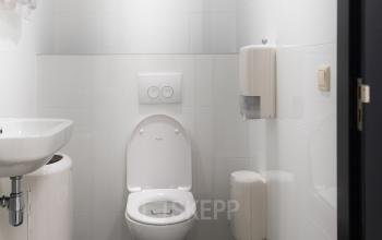 Moderne toiletruimte in het kantoorpand aan de Parlevinkerweg 1 in Venlo, netjes onderhouden en voorzien van een toilet, wastafel en handdoekdispensers.