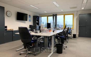 Modern ingerichte kantoorruimte met bureau's en comfortabele stoelen aan de Parlevinkerweg 1 in Venlo, ideaal voor teams die een professionele werkplek willen huren.
